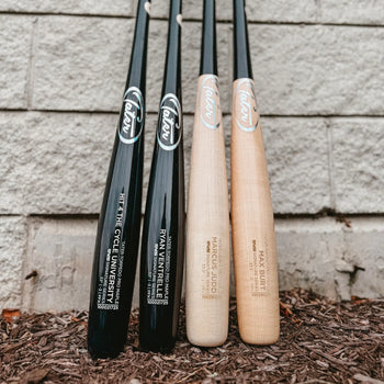 Tater custom maple wood bats including the slight end-load U238 model lined up against a cinder block wall