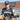 Baseball player in Wildcats uniform holding bat and glove at field
