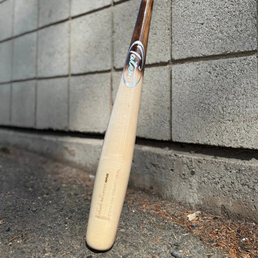 Custom Pine Tar style Tater Torpedo wood baseball bat leaning against a concrete wall, designed with sweet spot-loaded barrel for better contact and balanced power.